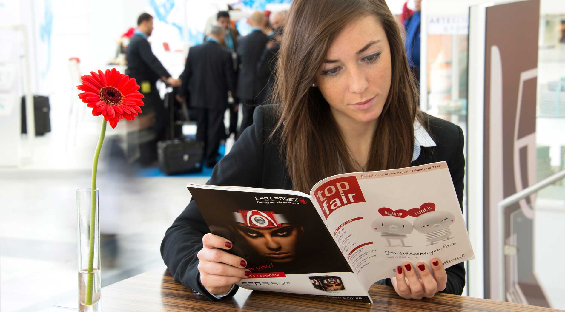 Frau liest die top fair der Messe Frankfurt